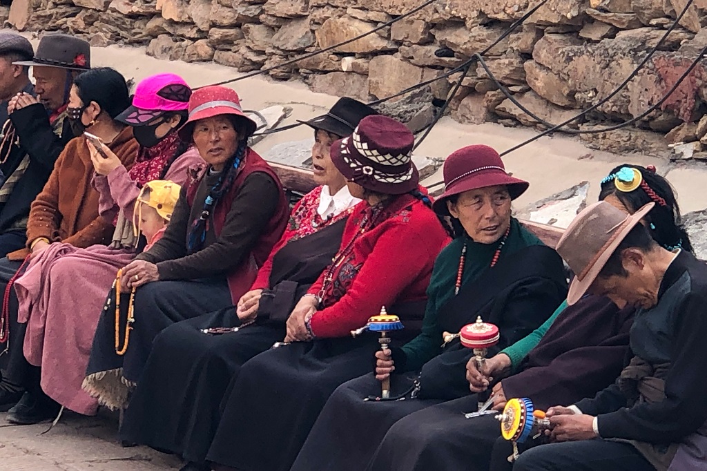 Tibetan ladies with prayer wheels beside the Derge Monastery